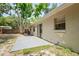 Exterior view of home with a cozy backyard, sliding glass doors, and a concrete patio at 2207 Valleybrook Ave, Valrico, FL 33594