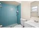 Bathroom featuring blue tile shower, mosaic floor, and white vanity with ample lighting at 2207 Valleybrook Ave, Valrico, FL 33594