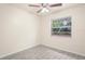 Well-lit bedroom with a ceiling fan and large window offering a glimpse of nature at 2207 Valleybrook Ave, Valrico, FL 33594