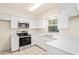 Bright kitchen featuring white cabinets, stainless steel appliances, and stone countertops at 2207 Valleybrook Ave, Valrico, FL 33594