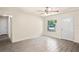 Living room featuring wood-look tile floors, a front door, and a large window for natural light at 2207 Valleybrook Ave, Valrico, FL 33594