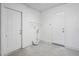 Bright utility room featuring two white doors, shelving, and plumbing fixtures for laundry appliances at 2207 Valleybrook Ave, Valrico, FL 33594