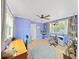 Bright bedroom featuring tile flooring, ceiling fan, ample windows, and versatile space at 235 38Th S St, St Petersburg, FL 33711