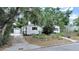 Charming single-story home featuring a well-lit front porch, black shutters, and a detached one-car garage at 235 38Th S St, St Petersburg, FL 33711
