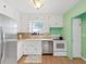 Kitchen with stainless appliances, bright green walls and white cabinetry at 235 38Th S St, St Petersburg, FL 33711