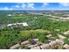 An aerial view shows a townhouse complex bordered by verdant trees and lush green space at 2418 Lake Woodberry Cir, Brandon, FL 33510