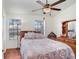 Bright bedroom features wood floors, a ceiling fan and natural light from the two windows at 2418 Lake Woodberry Cir, Brandon, FL 33510