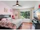 Bedroom featuring wood floors, a ceiling fan, and a large window with natural light at 2418 Lake Woodberry Cir, Brandon, FL 33510
