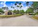 Inviting community entrance featuring a stately sign amidst manicured landscaping and palm trees at 2418 Lake Woodberry Cir, Brandon, FL 33510