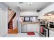 Modern kitchen with stainless steel appliances, granite countertops and view of the wood staircase at 2418 Lake Woodberry Cir, Brandon, FL 33510