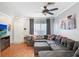 Comfortable living room with a large sectional sofa, ceiling fan, and wood floors at 2418 Lake Woodberry Cir, Brandon, FL 33510