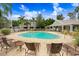 Community pool surrounded by lounge chairs with community buildings in the background at 2418 Lake Woodberry Cir, Brandon, FL 33510