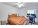 Bedroom featuring a ceiling fan, a window providing natural light, and a desk with two monitors at 2452 Brazilia Dr # 32, Clearwater, FL 33763