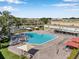Elevated view of a community pool surrounded by lounging areas and nearby buildings at 2452 Brazilia Dr # 32, Clearwater, FL 33763