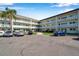 Exterior of building showing three-story condo and parking area and some landscaping at 2452 Brazilia Dr # 32, Clearwater, FL 33763