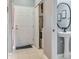 Hallway bathroom includes pedestal sink, decorative mirror and adjacent hall closet/laundry at 30340 Elderwood Dr, Wesley Chapel, FL 33543