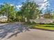 Hillhurst Crossing community entrance featuring stone signage, landscaped greenery, and a well-maintained road at 30340 Elderwood Dr, Wesley Chapel, FL 33543