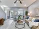 Contemporary living room features a ceiling fan, patio access, and neutral color scheme at 30340 Elderwood Dr, Wesley Chapel, FL 33543