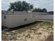 Side view of backyard with a newly painted house and a white vinyl fence, perfect for privacy at 3301 Clydesdale Dr, Holiday, FL 34691