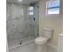 Bright bathroom featuring a tiled shower, modern toilet and updated vanity at 3301 Clydesdale Dr, Holiday, FL 34691