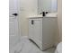 White bathroom vanity with black hardware, faucet, and marble flooring at 3301 Clydesdale Dr, Holiday, FL 34691