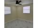 Bedroom features two windows, a ceiling fan with a light, and white flooring with gray marbling at 3301 Clydesdale Dr, Holiday, FL 34691