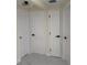 Hallway features three white doors with black hardware and white flooring with gray marbling at 3301 Clydesdale Dr, Holiday, FL 34691