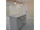 This kitchen features an island with white cabinets, black hardware, and bright hanging lights above it at 3301 Clydesdale Dr, Holiday, FL 34691