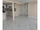 Open-concept living room with lots of space, white walls and doors, and white flooring with gray marbling at 3301 Clydesdale Dr, Holiday, FL 34691