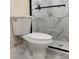 Toilet in bathroom with the marble-look tile in shower in the background at 3301 Clydesdale Dr, Holiday, FL 34691