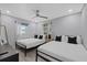 Bright bedroom featuring two beds, ceiling fan and light walls at 4003 W Bay Ave, Tampa, FL 33616