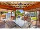 Covered deck area with a glass top table, chairs, and overhead lighting at 4003 W Bay Ave, Tampa, FL 33616