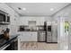 Updated kitchen with stainless steel appliances, granite countertops, sleek cabinetry, and a mosaic backsplash at 4003 W Bay Ave, Tampa, FL 33616