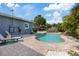 Inviting pool features a paver deck, lush landscaping, and a pergola in the background at 4003 W Bay Ave, Tampa, FL 33616