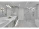Bright bathroom featuring double vanity, glass enclosed shower, and marble flooring at 455 Pinellas Bayway S # 2A, Tierra Verde, FL 33715