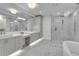 Modern bathroom featuring dual sinks, a spacious shower, and marble flooring at 455 Pinellas Bayway S # 2A, Tierra Verde, FL 33715