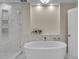 Elegant bathroom featuring a soaking tub and a tiled shower with a built-in shelf at 455 Pinellas Bayway S # 2A, Tierra Verde, FL 33715