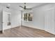 Bedroom with hardwood floors, ceiling fan, and a large window overlooking greenery at 455 Pinellas Bayway S # 2A, Tierra Verde, FL 33715