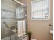 A recently renovated bathroom with glass shower, including accessibility features, and a neutral color palette at 4851 W Gandy Blvd # B09L23, Tampa, FL 33611