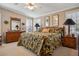 This bedroom features a large bed with a tropical print comforter, lamps and furniture at 4851 W Gandy Blvd # B09L23, Tampa, FL 33611