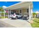 Spacious carport accommodating a car and a golf cart, with a cozy screened-in porch nearby at 4851 W Gandy Blvd # B09L23, Tampa, FL 33611