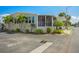 Well-maintained single-story home with lush landscaping, a screened porch, and covered parking at 4851 W Gandy Blvd # B09L23, Tampa, FL 33611
