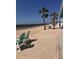 A view of the beach with two chairs, tall palm trees, clear skies, and the ocean at 5557 Sea Forest Dr # 216, New Port Richey, FL 34652