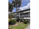Multi-story condo building featuring screened balconies and lush landscaping with palm trees at 5557 Sea Forest Dr # 216, New Port Richey, FL 34652