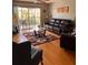 Comfortable living room with hardwood floors, leather seating, and access to a balcony at 5557 Sea Forest Dr # 216, New Port Richey, FL 34652