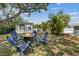Inviting backyard fire pit with chairs, creating a cozy outdoor gathering space surrounded by mature trees and lush greenery at 5805 S Hubert Ave, Tampa, FL 33616