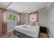 This bedroom features a cozy bed, ceiling fan, and windows draped with patterned curtains at 5805 S Hubert Ave, Tampa, FL 33616