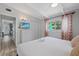 Bright bedroom with a ceiling fan, white dresser, and a door that leads to the kitchen at 5805 S Hubert Ave, Tampa, FL 33616