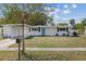 Attractive home showcasing a well-kept lawn, carport, and a delightful blue front door at 5805 S Hubert Ave, Tampa, FL 33616