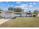 Charming single-story home featuring a covered carport, blue entry door, and tidy front yard at 5805 S Hubert Ave, Tampa, FL 33616